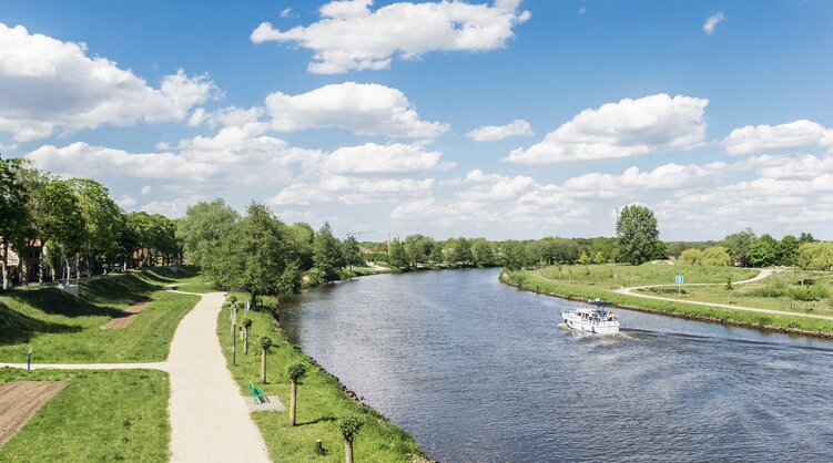 Die Ems bei Haren | © Bildlizenzen von Shutterstock.com Flusskurve der Ems mit weißem Schiff neben Radweg bei Haren | © Bildlizenzen von Shutterstock.com