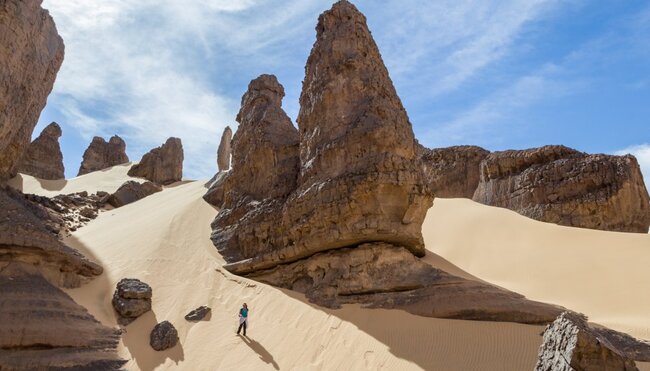 Frau geht eine Düne in der algerischen Wüste hinunter
