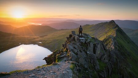 Wanderer bei Sonnenaufgang auf Gipfel des Helvellyn