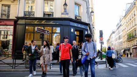 Intrepid group with leader talking to traveller exploring the streets of Marais in Paris, France