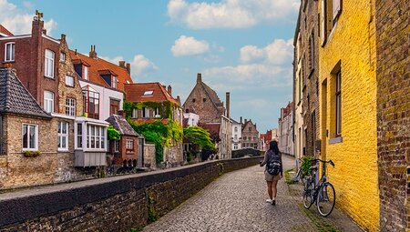 Traveller walks along Bruges canals