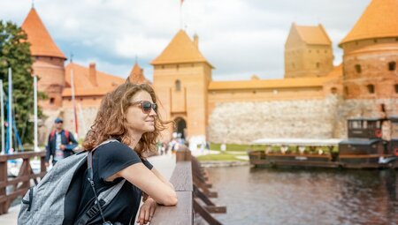 Traveller on the bridge to Trakai castle in Lithuania