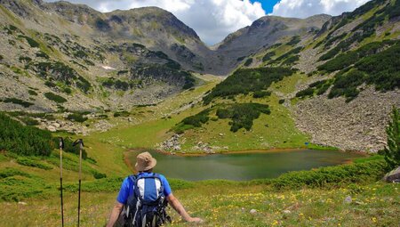 Traveller takes a break at Prevalski Lake in Pirin Mountains, Bulgaria