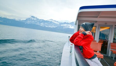 Intrepid traveller looks out from boat ride across Lake Lucerne in autumn