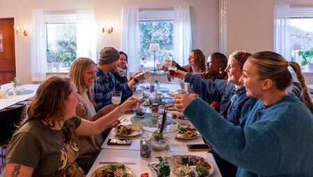 Intrepid group of travellers cheers drinks over a fine dinner in Sweden