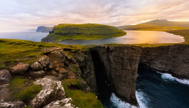 Lake Sørvágsvatn lit by sunset suspended over high cliffs in the Faroe Islands on the Traelanipan Trail
