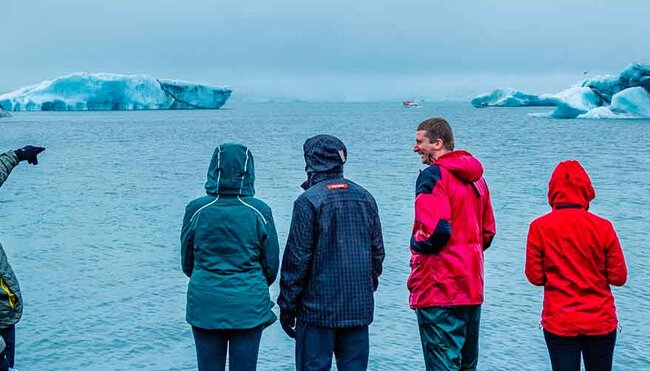 Group of travellers look at Jokulsarlon Glacier from the coastline