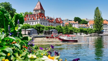 Brightly coloured Chateaux D'ouchy with flowers and docks on Lake Leman in Lausanne, Switzerland