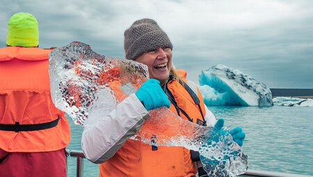Traveller holding ice shard on Jokulsarlon Glacier Lagoon Boat Tour