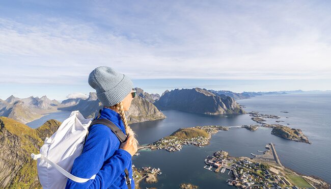 Hiker looking out at islands from view point in Lofoten, Norway