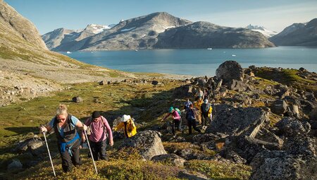 Travellers on hike near Fjord in Greenland