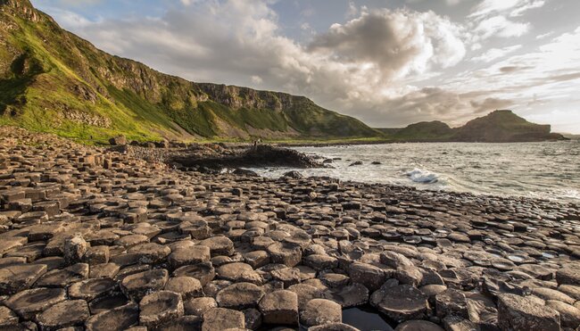 Travellers in the distance explore the Giants Causeway on the northern shore of Ireland
