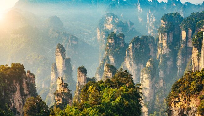 Towering pillars of sandstone topped with trees and dot the landscape of Zhangjiajie National Forest Park, Hunan