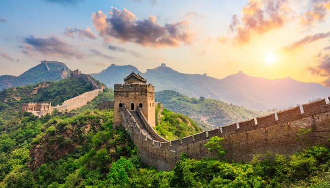 The Great Wall of China hit by the rising sun over the mountain peaks in northern China
