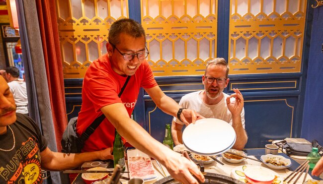 Intrepid leader stirs a sichuan hotpot for a traveller in Chengdu China