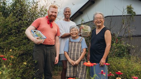 Intrepid travellers pose with the Hosts of the homestay Hananeko in Kawane, with baskets of fresh-picked vegetables