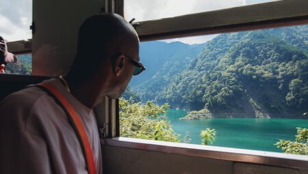 Happy traveller looking out over a river in Japan's mountainous countryside