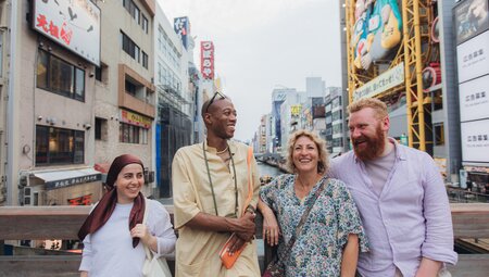 Intrepid travellers stop on a bridge to take a break from exploring in Osaka