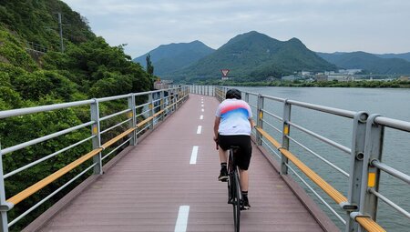 Traveller cycling on the 4 Rivers Bike Trail on a suspended bike path over the waters of the Han River in South Korea