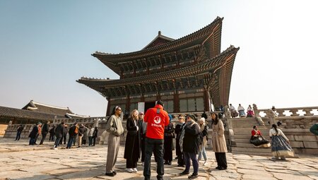 Leader giving a talk to group on the grounds of Gyeongbokgung Palace in South Korea