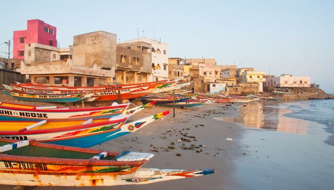 Traditional colourfully painted fishing boats on the beach of Dakar in Senegal