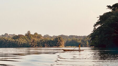 Locals out with a punting canoe ride on the Moa river near Tiwai Island in Sierra Leone