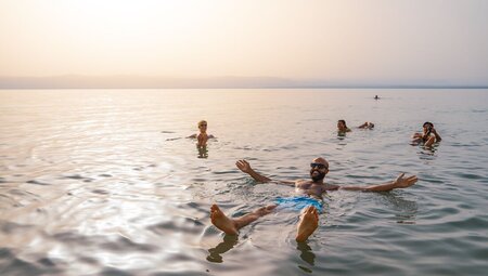 Intrepid travellers and leader floating in the Dead Sea in Jordan