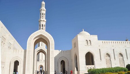 Exterior of the Grand Mosque in Muscat with travellers carrying through to the interior in Oman