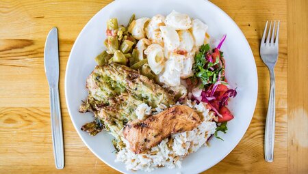Plate of fresh healthy food with meat on a neat plate with wooden table