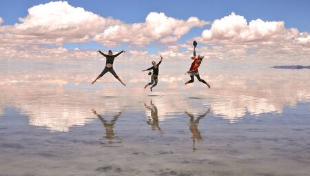 Travellers jumping on the salt flats of salar de uyuni, Bolivia