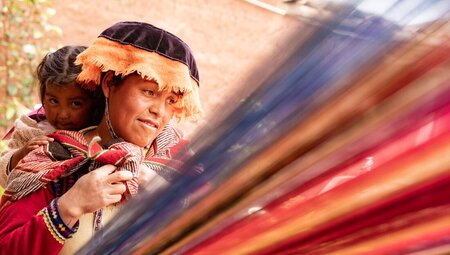 Local mother and child during weaving demonstration in Sacred Valley Ollantaytambo Peru