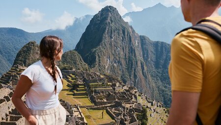 Intrepid travellers look out at the mountains and archaeological site of Machu Picchu in Peru mountains