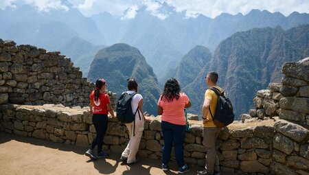 Intrepid group and leader look out over the mountains of Peru at Machu Picchu