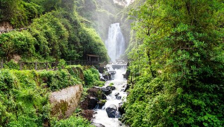 View of Peguche Waterfall surrounded by green vegetation in Ecuador