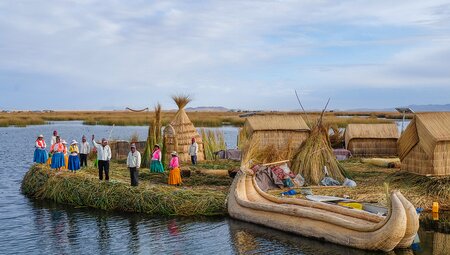 Locals waving welcome on floating island, Lake Titicaca, Peru