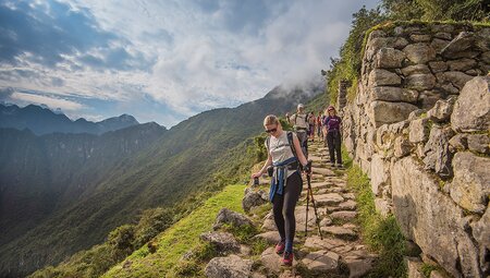 Group trek down cobbled path along Inca Trail, Machu Picchu, Peru