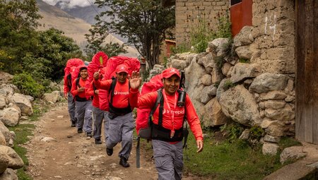Intrepid porters wave and smile at the camera as they begin hiking the Inca trail