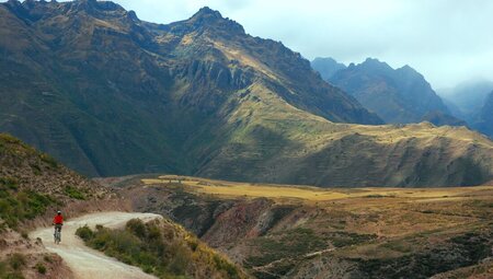 Intrepid leader on mountain bike rides ahead of group in Sacred Valley in Peru