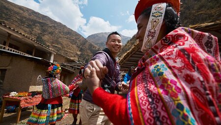 Intrepid traveller dancing with Huilloc community members in Peru Sacred Valley