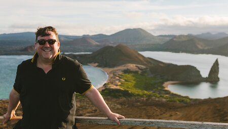 Traveller smiling in front of scenic view, Isla Bartolome, Galapagos Islands