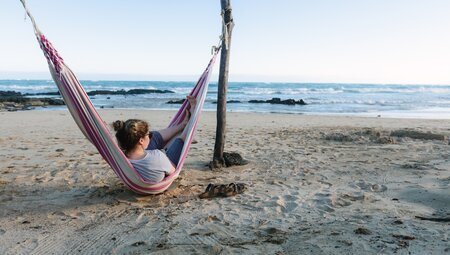 Traveller swinging in a hammock, Galapagos Islands, Ecuador