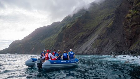 Intrepid group on a zodiac excursion around the mountainous coast of Isla Isabela in the Galapagos