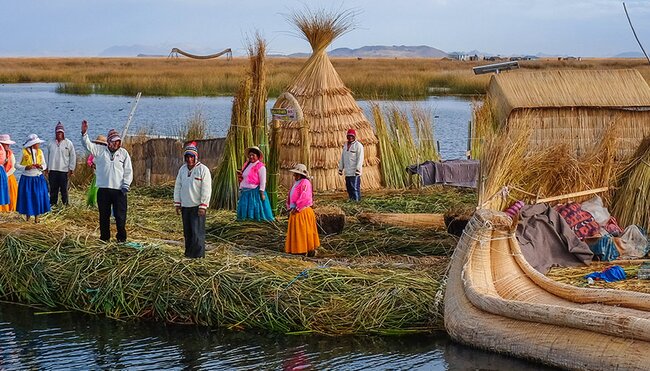 Local villagers wave welcome on floating islands, Lake Titicaca, Peru