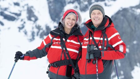 Travellers on a Danco Island hike smile at the camera in Antarctica