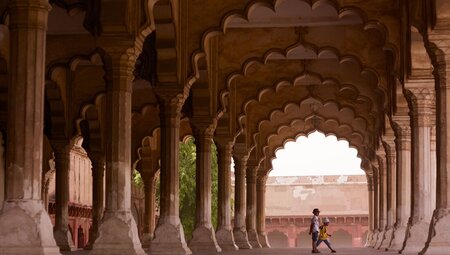 Children play among the intricate pillars of Agra's Red Fort in India's Golden Triangle