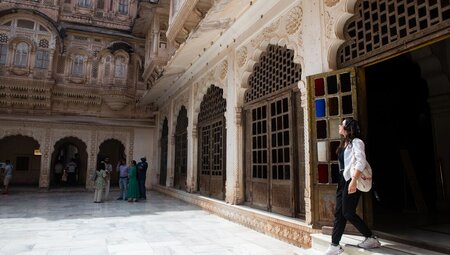 Traveller looking up at the architecture is she walks around inside Mehrangarh Fort, Jodhpur, India