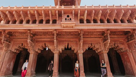 Travellers standing in the elaborate doorways of Red Fort in Agra, India on an Intrepid Travel tour.