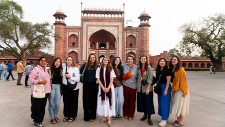 Travellers smiling as they take a photo in front of Jawab Masjid in Agra, India