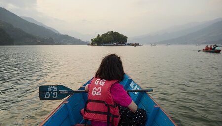 Intrepid traveller on a rowboatenture onto Phewa Lake in Pokhara, Nepal