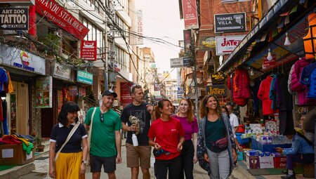Group of Intrepid travellers with leader explore the streets of Kathmandu in Nepal